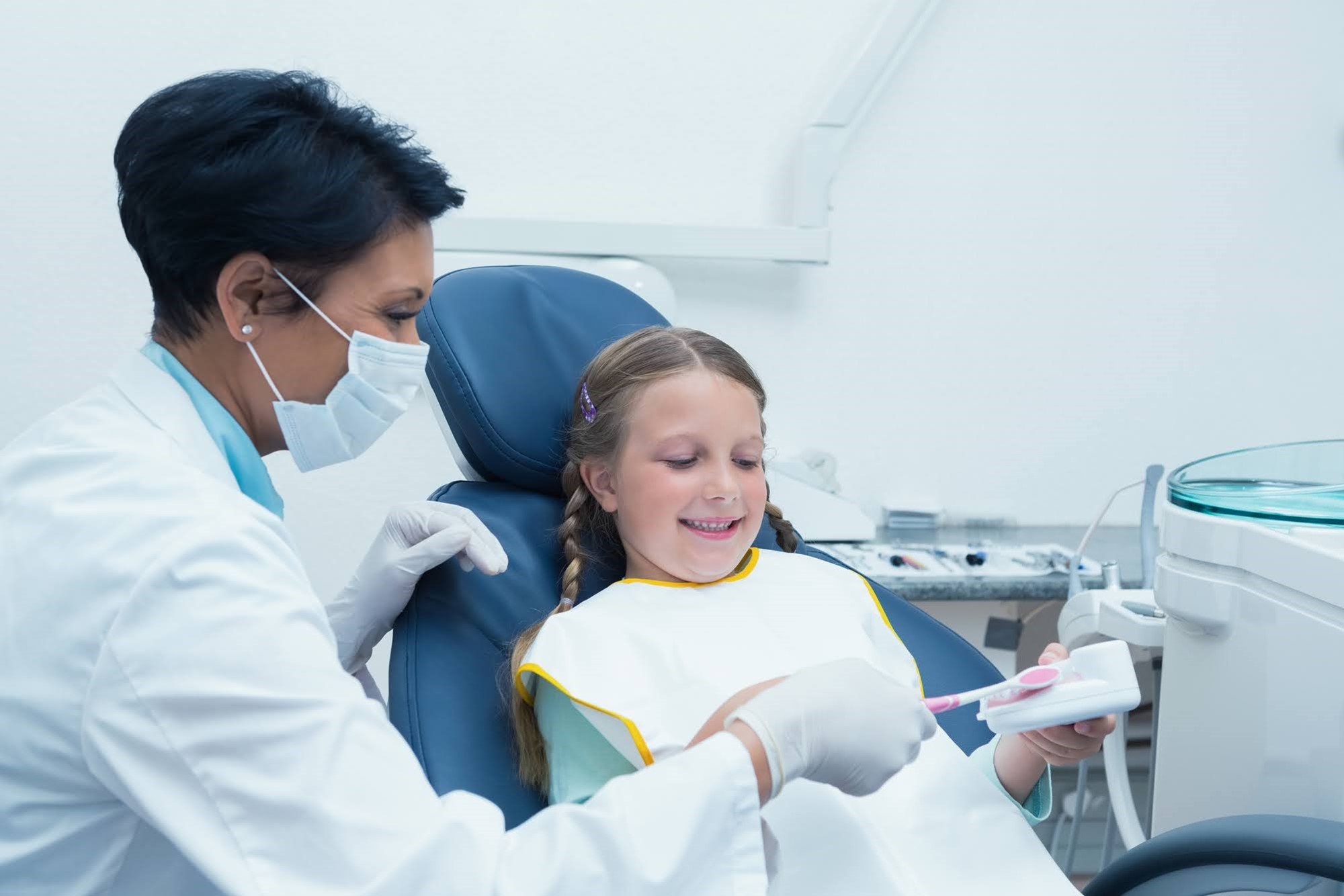 A dentist examining a young female patient.